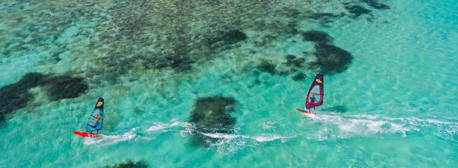 Windsurfeurs en action sur le lagon avec une eau paradisiaque turquoise et transparente à Madagascar