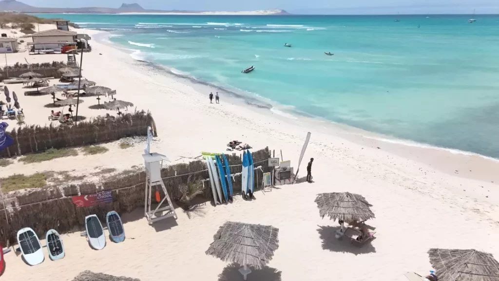 Vue aérienne d'une plage de sable blanc et d'une école de glisse au bord d'une eau turquoise à Boa Vista au Cap-Vert.