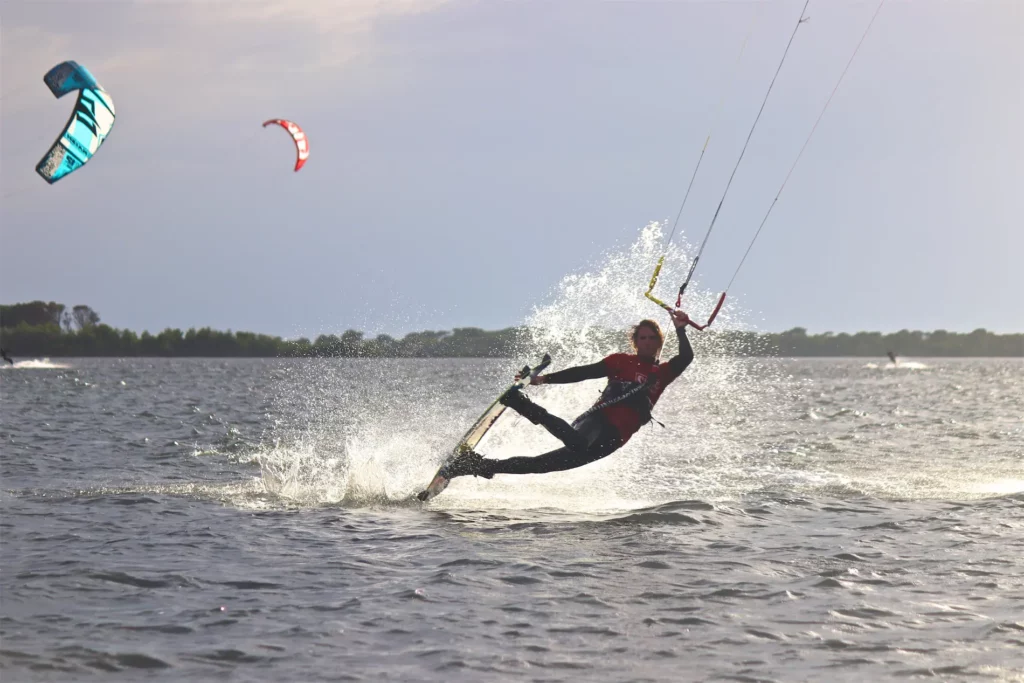 Un kitesurfeur réalise une figure en glissant sur l'eau et en créant des éclaboussures à Lo Stagnone en Sicile.